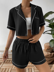 Black cropped shirt worn open over a white top with matching drawstring shorts