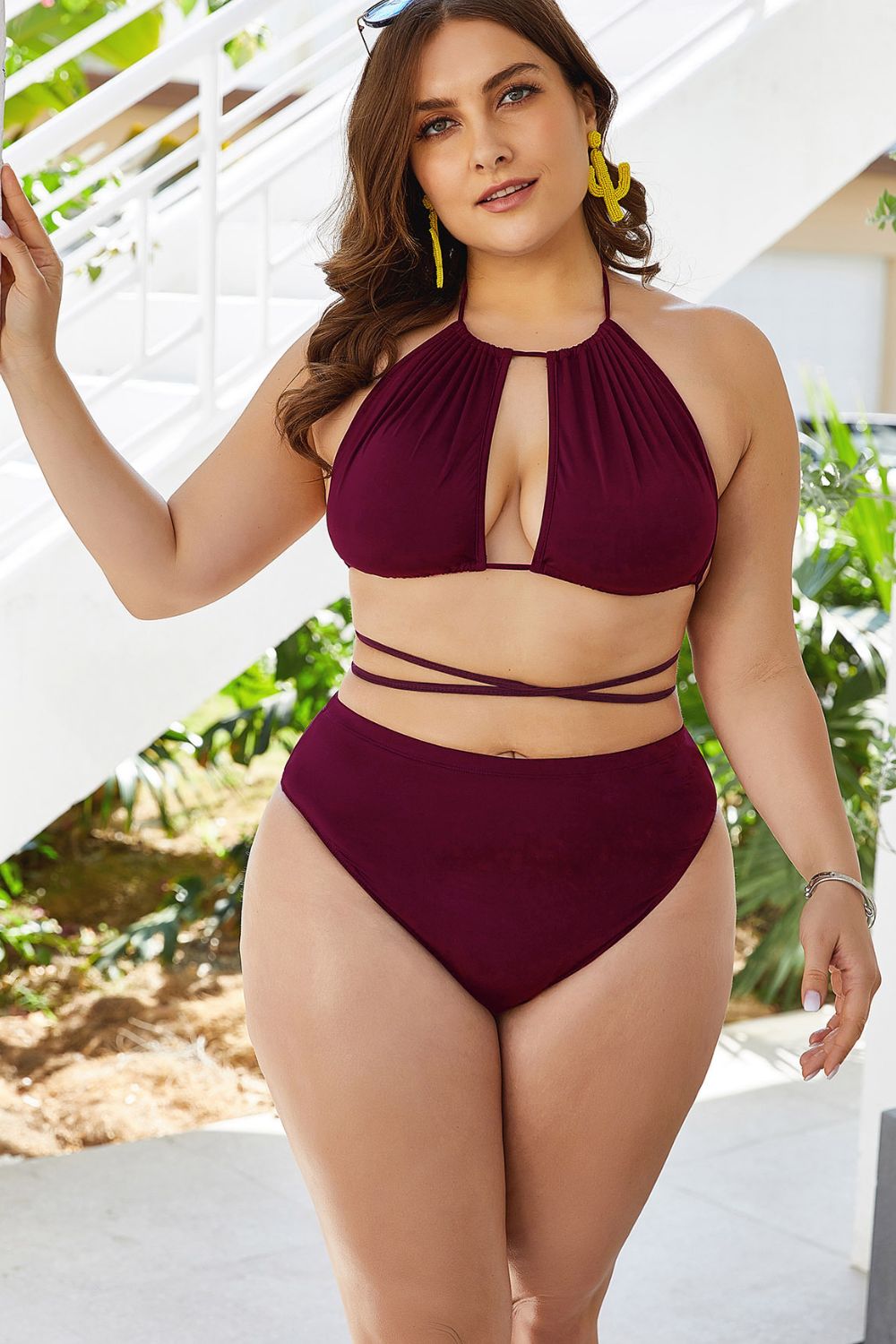 Burgundy bikini with gathered halter top and wraparound waist ties, worn beside steps