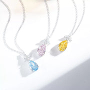 Three teardrop zircon necklaces in pastel blue, blush pink and light yellow on a white display