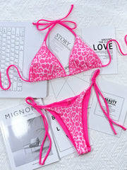Pink leopard bikini set laid flat with matching tie straps