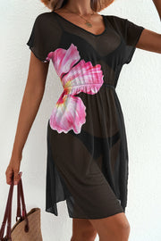 Model wearing black semi-sheer cover-up with pink floral print
