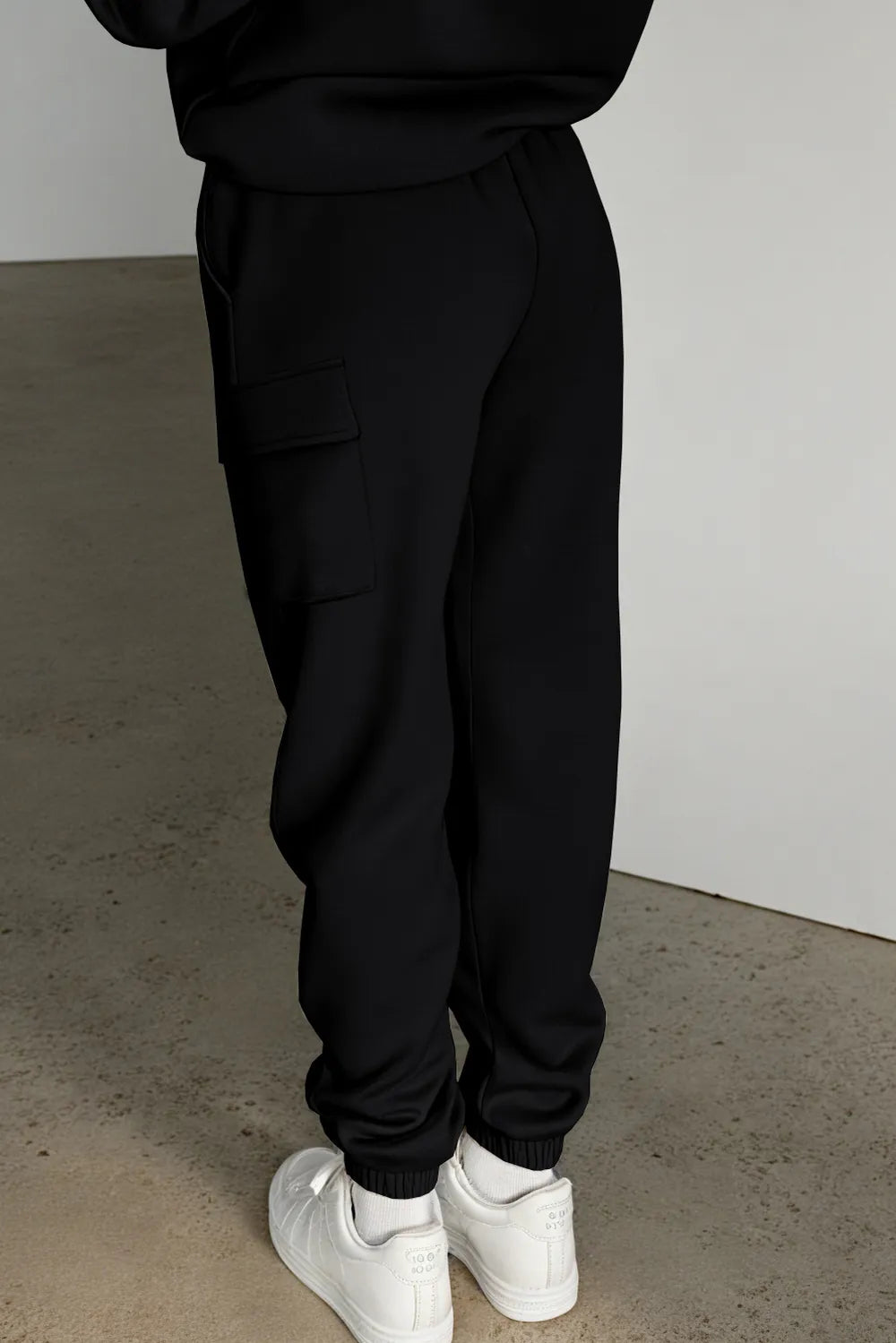 Side view of black joggers showing cargo pocket and elastic cuffs