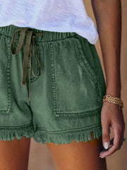 Close view of green denim shorts showing the drawstring and front patch pockets