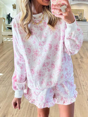 Model wearing pink floral sweatshirt and ruffle-hem shorts set