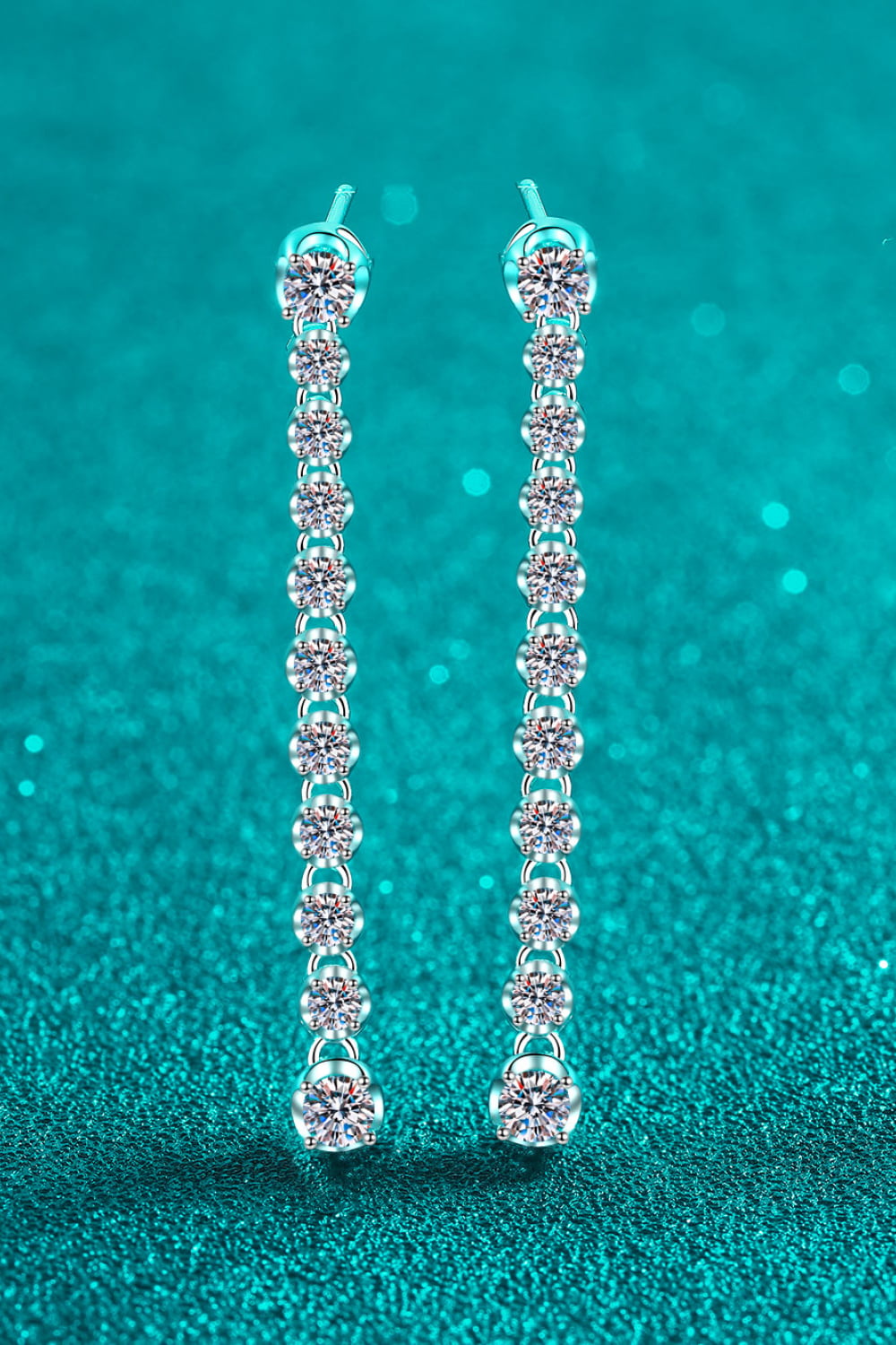 Adored 1.18 Carat Moissanite Long Earrings — Front view of long moissanite earrings on teal background