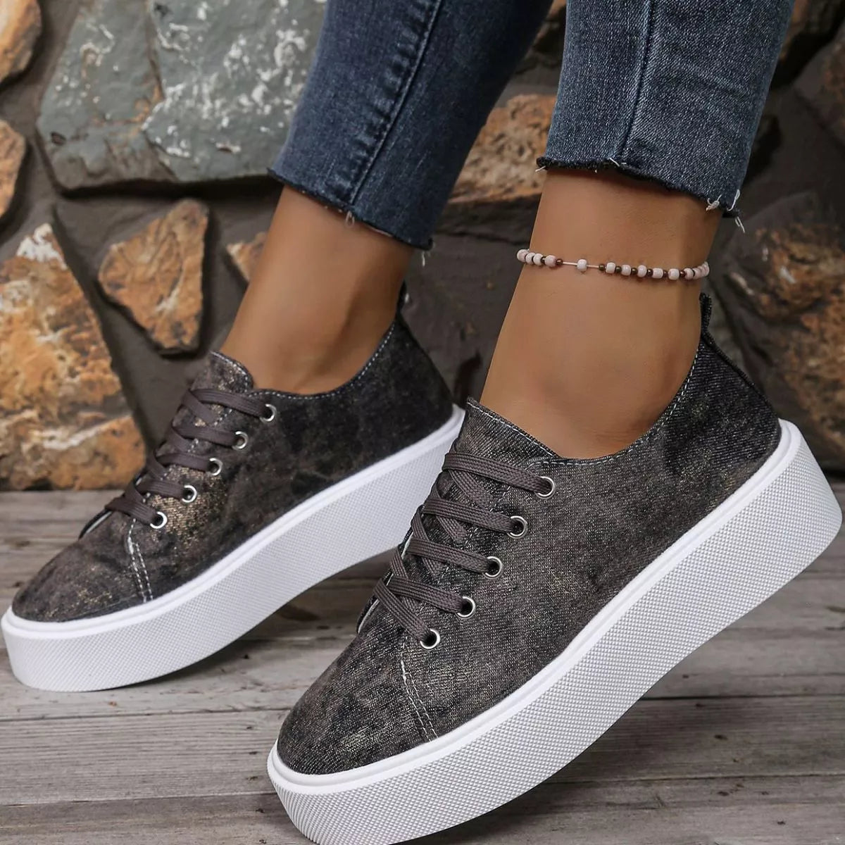 Angled front view of charcoal patterned platform sneakers worn with cropped jeans