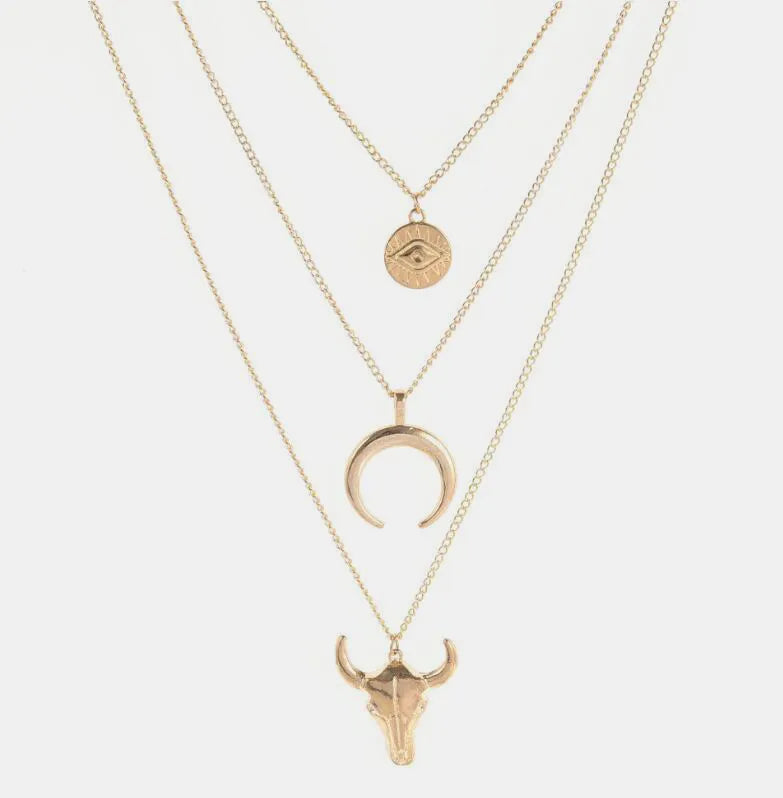 Gold-tone three-layer necklace with round medallion, crescent and bull head pendants