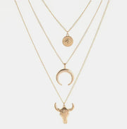 Gold-tone three-layer necklace with round medallion, crescent and bull head pendants