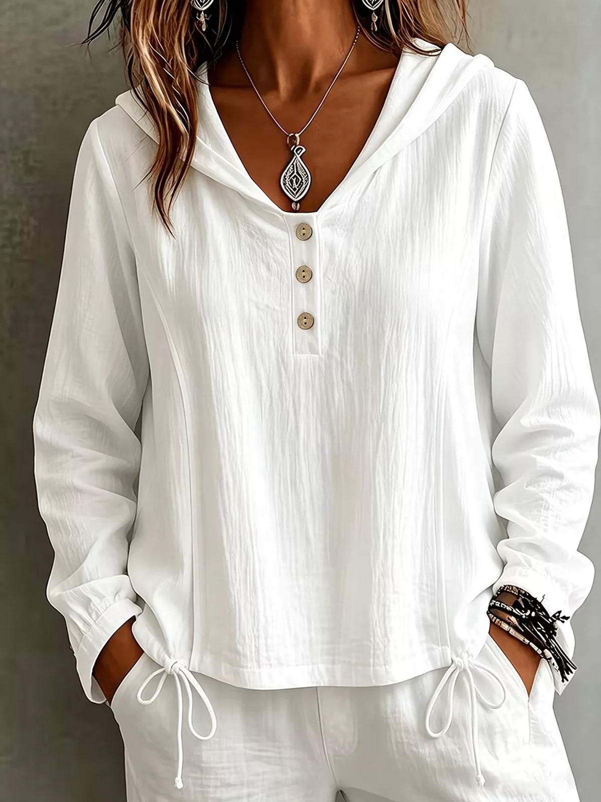 Women's white hooded long-sleeve blouse with button details and drawstring