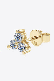 Close-up of gold-tone three-stone moissanite stud and post