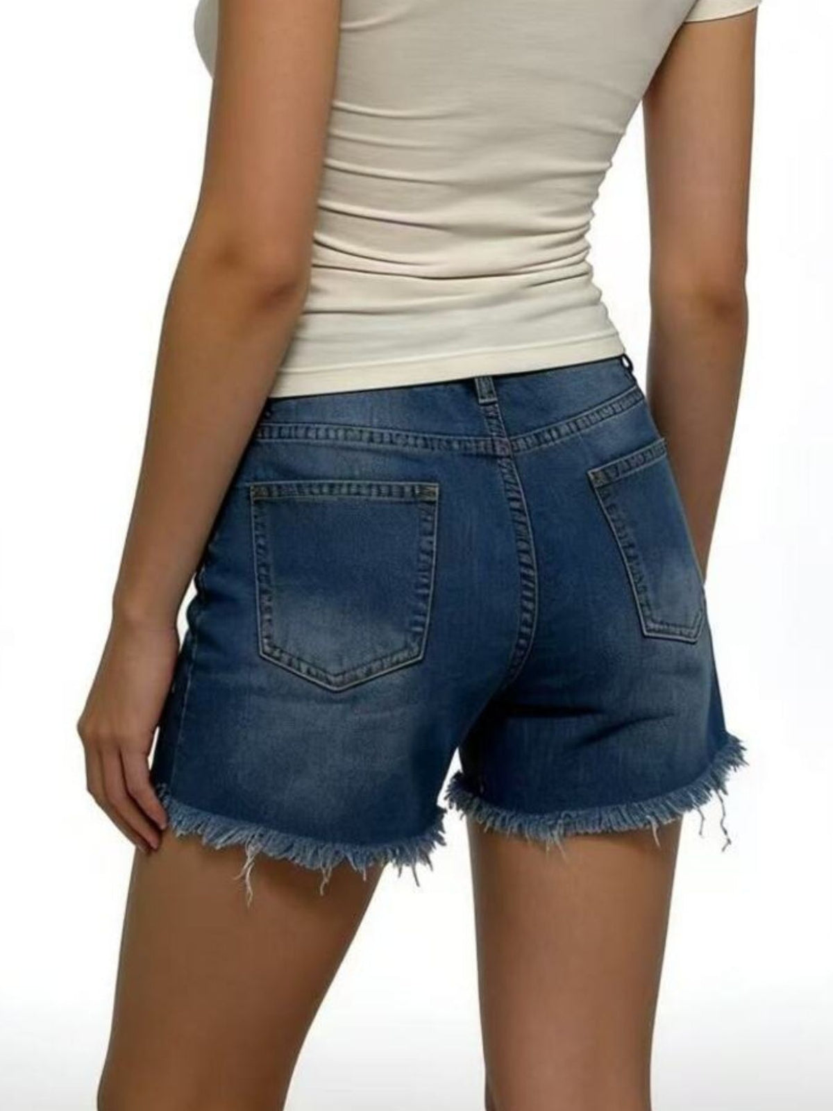 Rear view of blue denim shorts showing two patch pockets and frayed hems