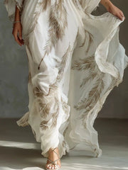 Lower view of the brown feather-print maxi dress showing its flowing skirt and ruffled edge.