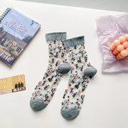 Pair of floral sheer socks with blue-gray cuffs and toes