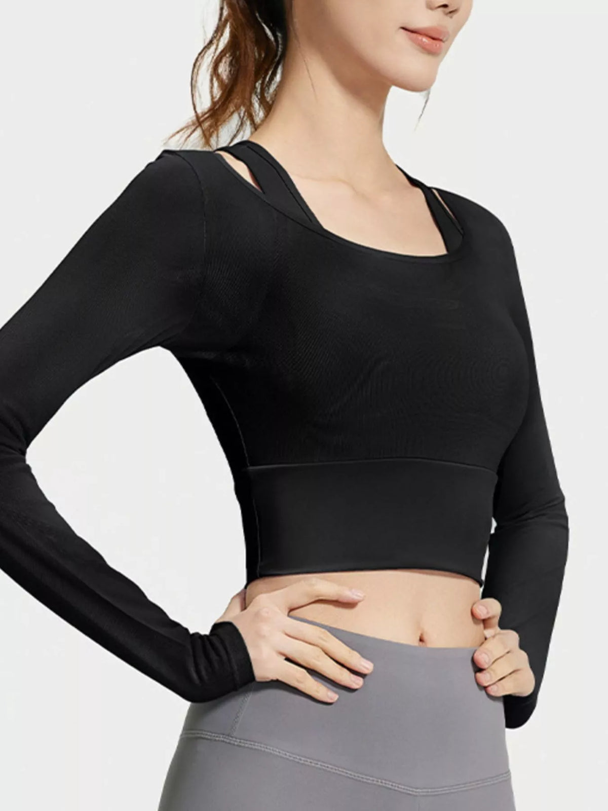 Angled view of black long-sleeve active top showing inner shoulder straps and wide underbust band