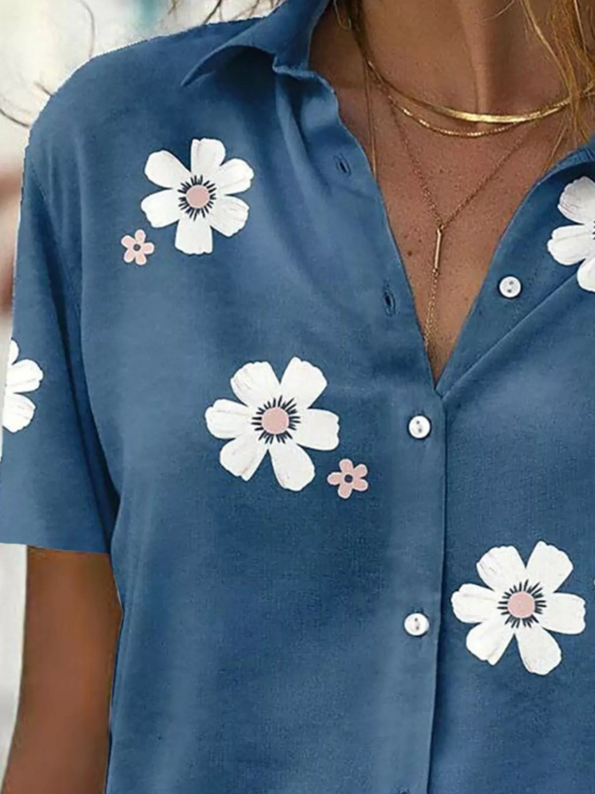 Close-up of white flowers and the button placket on the blue shirt.