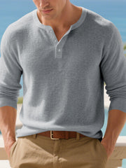 Front view of a navy long-sleeve Henley shirt styled with khaki pants.