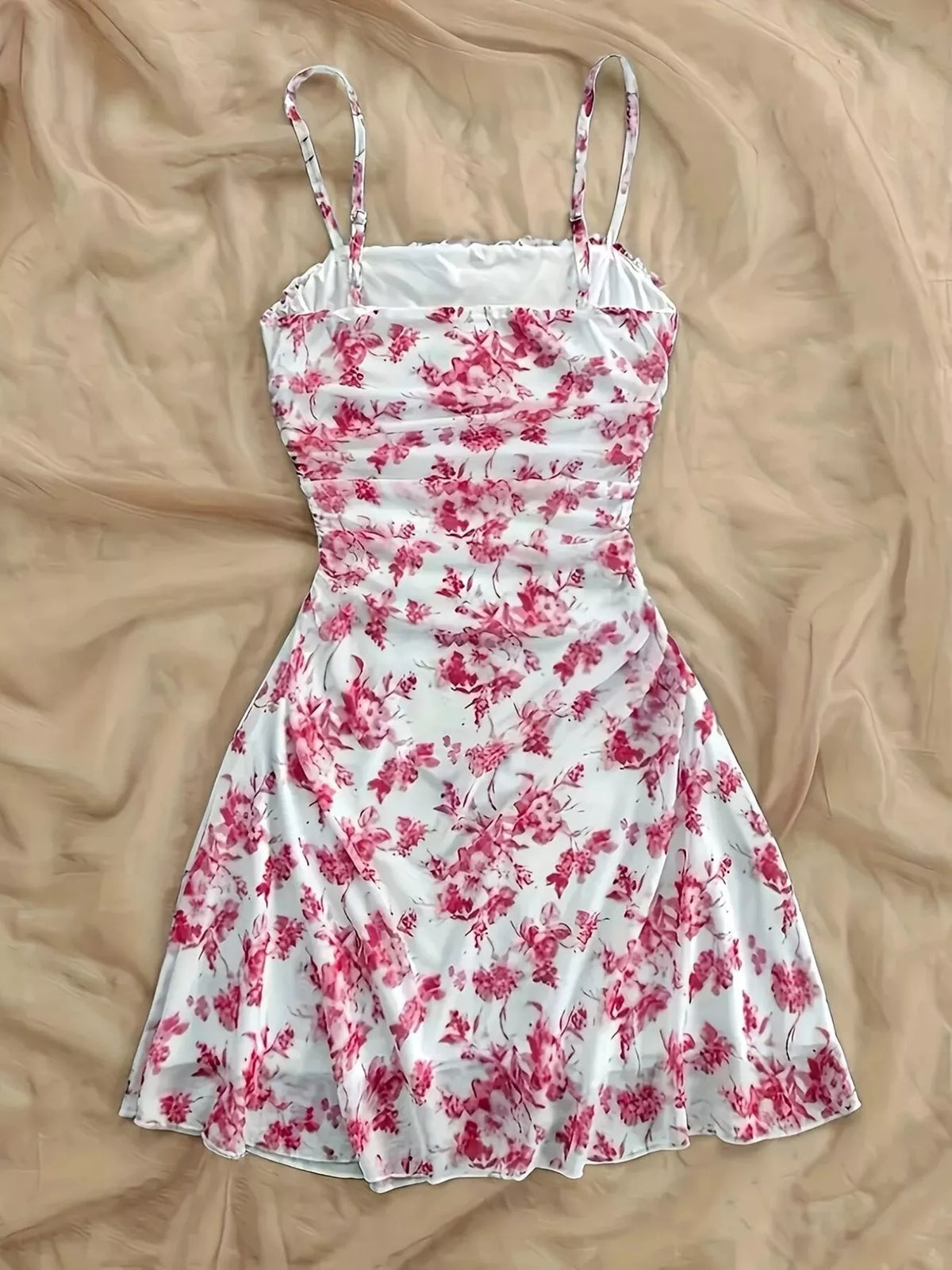 Pink floral spaghetti-strap mini dress laid flat, full front