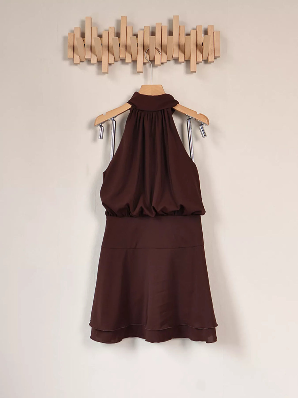 Back view of dark brown dress on a hanger, showing gathered upper section and tiered skirt