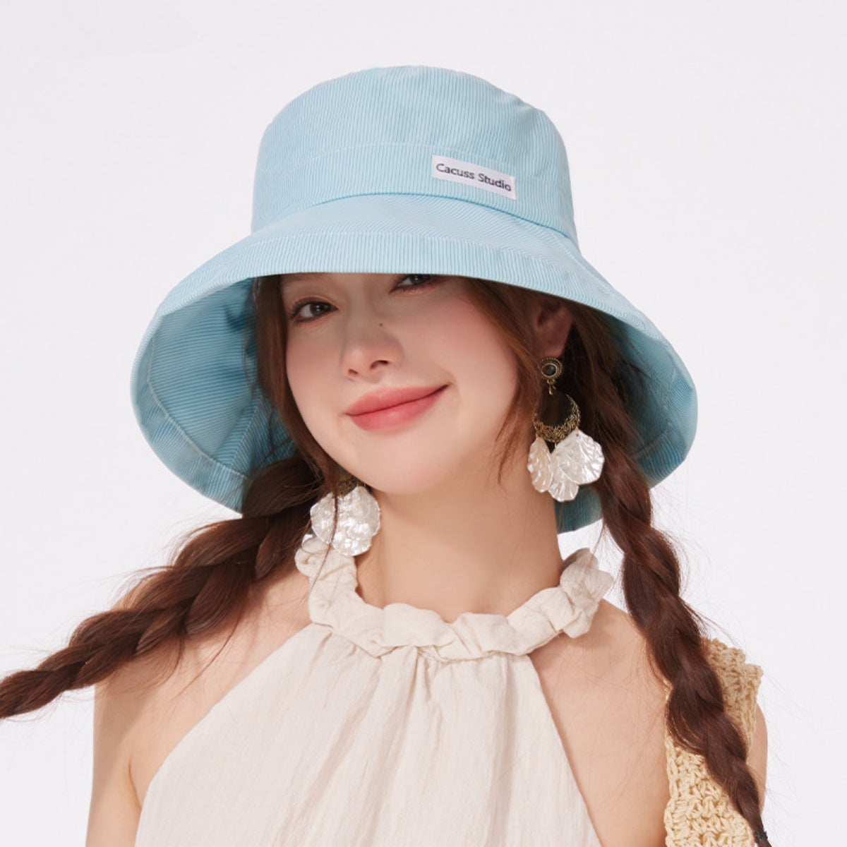 Front view of a model in a mint green wide-brim sun hat.