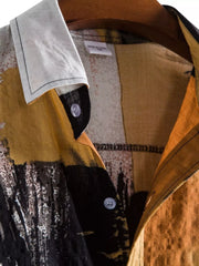 Close-up of the collar and buttons on the ochre color-block shirt