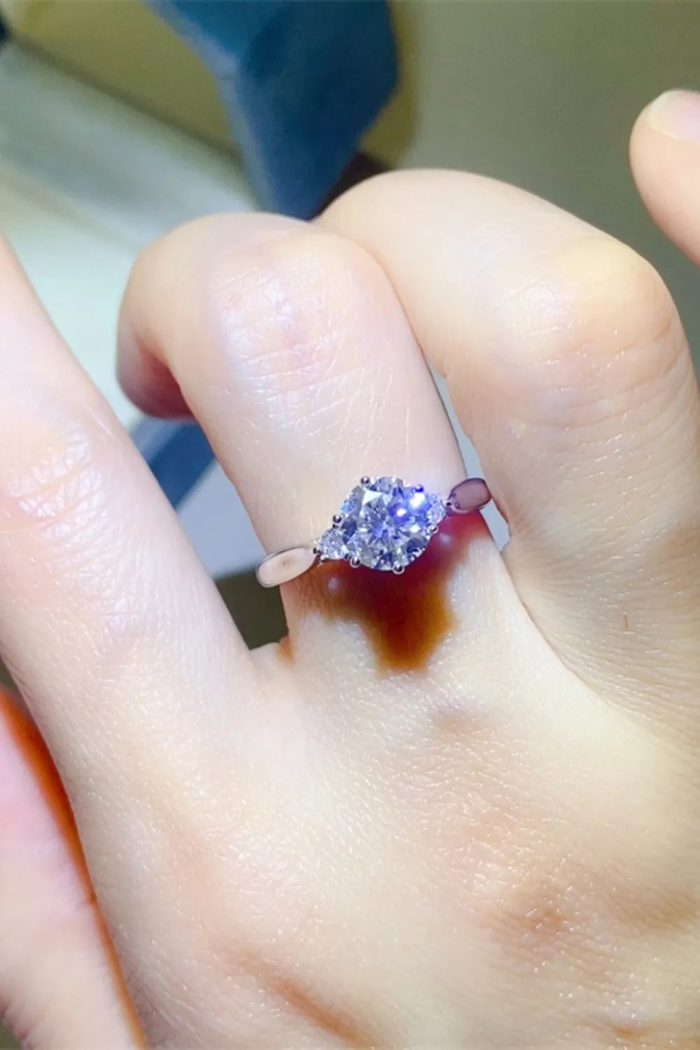 Purple centre-stone ring worn on a finger with a decorative gold-tone band