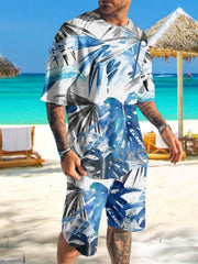 Man wearing white shirt and shorts with blue and black abstract print on a beach