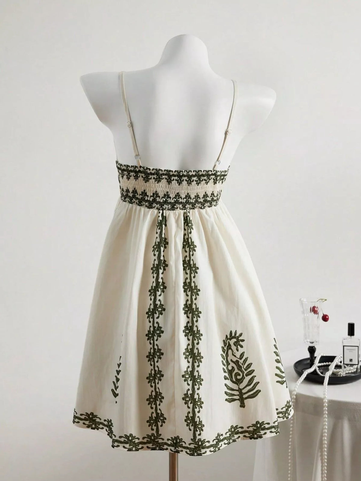 Back view showing embroidered waistband on ivory sleeveless dress