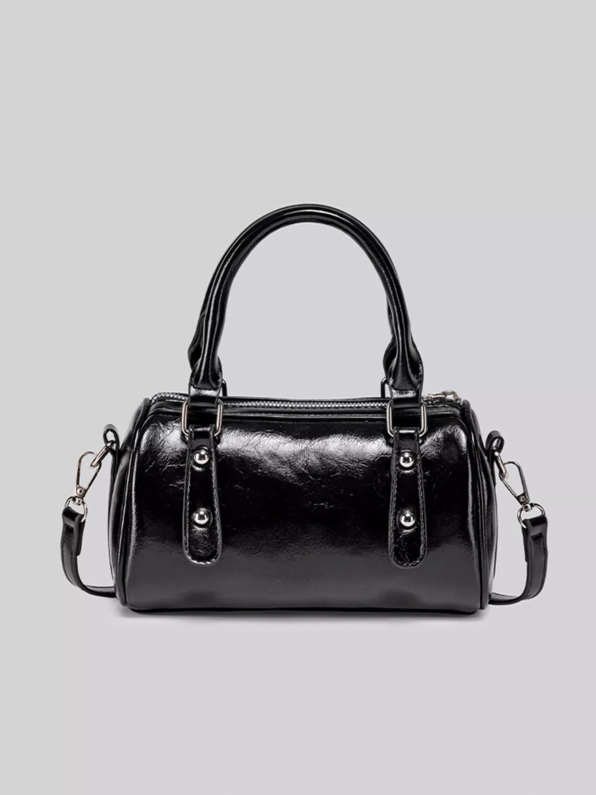 Front view of the glossy black Boston bag showing its two top handles and decorative front tabs.