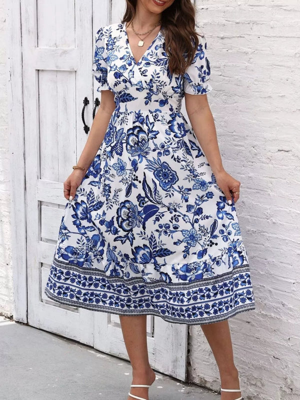 Front view of the blue and white floral V-neck midi dress, with the skirt held out at both sides.