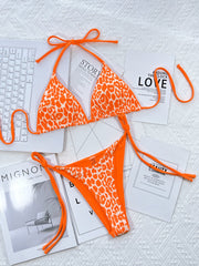 Turquoise bikini with pale patterned bottoms laid flat