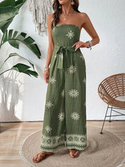 Model wearing printed tube jumpsuit with hand at waist