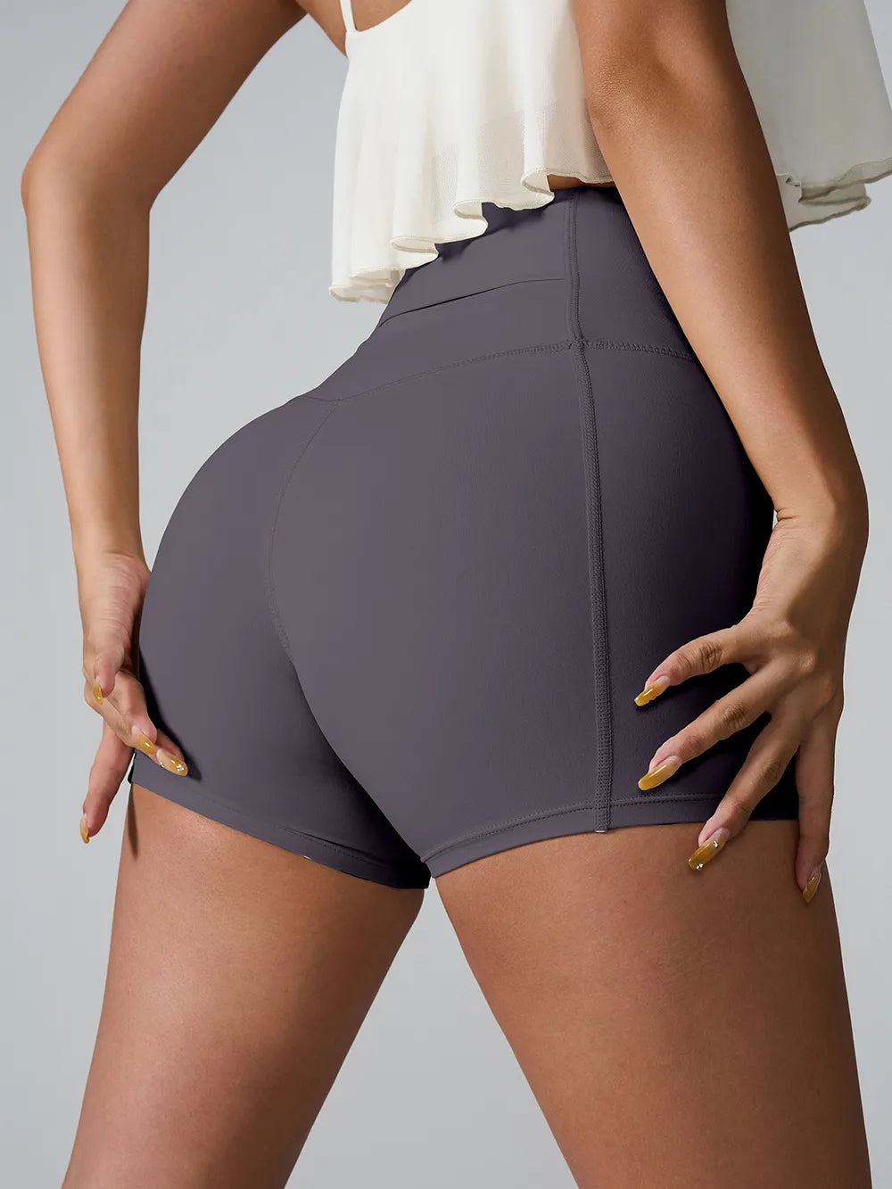 Rear angled view of plum fitted active shorts with a wide waistband.