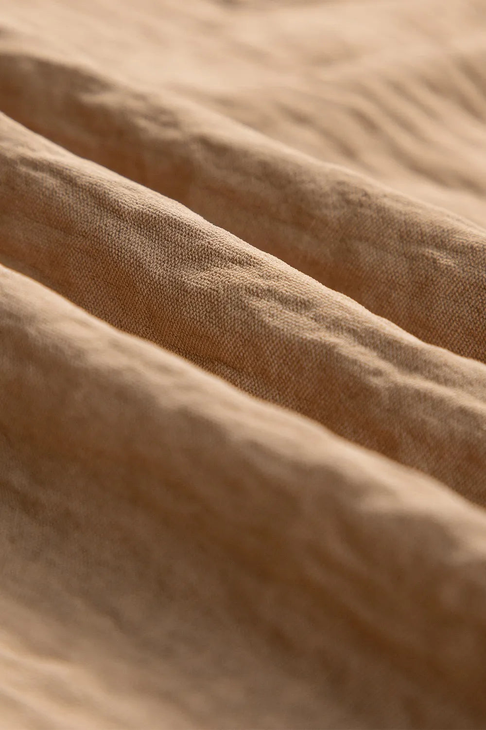 Detail of the soft woven fabric on tan utility trousers
