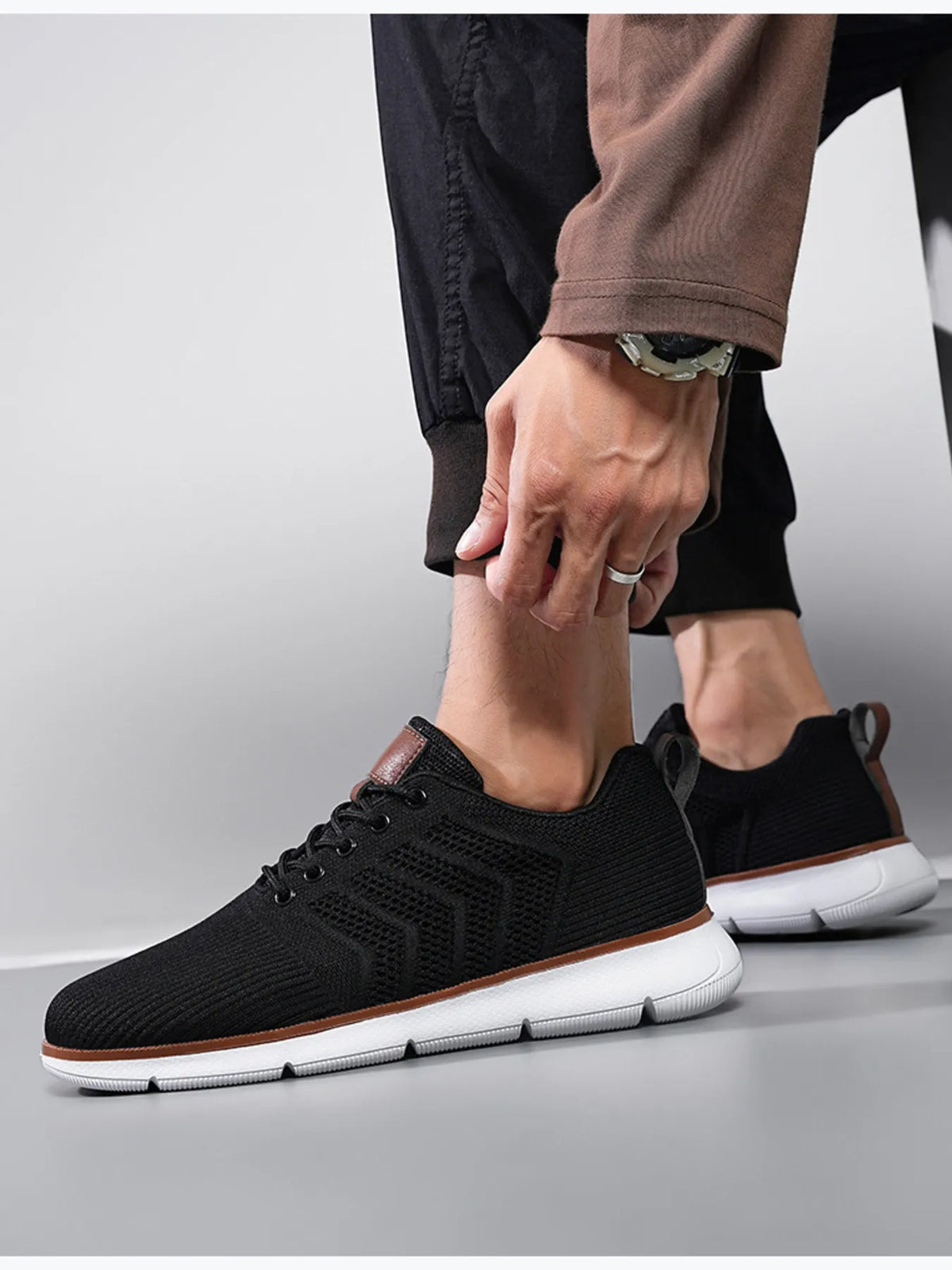 Black mesh lace-up shoes shown from the side with black trousers