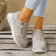 White sneakers worn with jeans, angled view