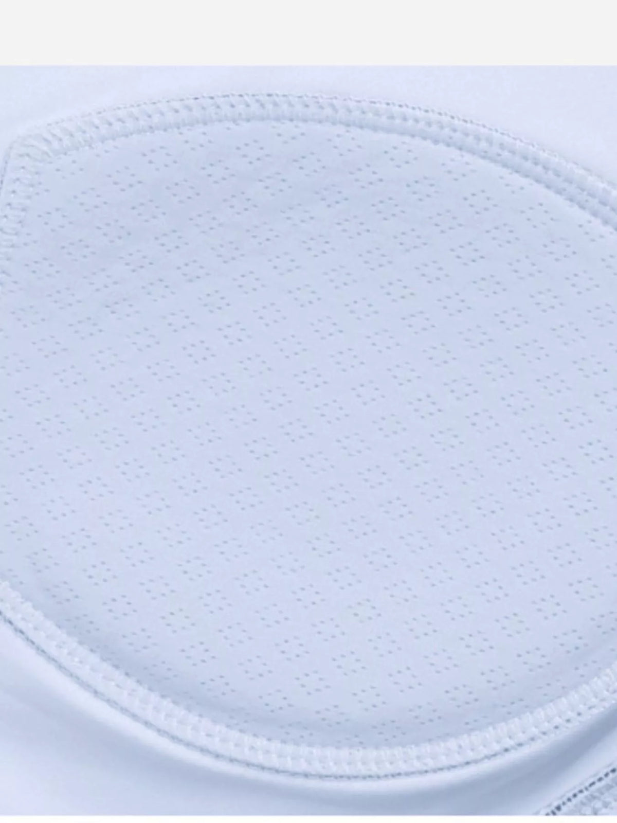 Close-up of light blue perforated bra cup padding and stitched edge