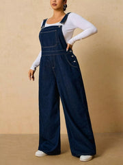 Angled view of dark blue overalls showing adjustable straps and side buttons, hand at the waist.