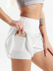 White high-waisted running shorts with phone in side pocket, close view