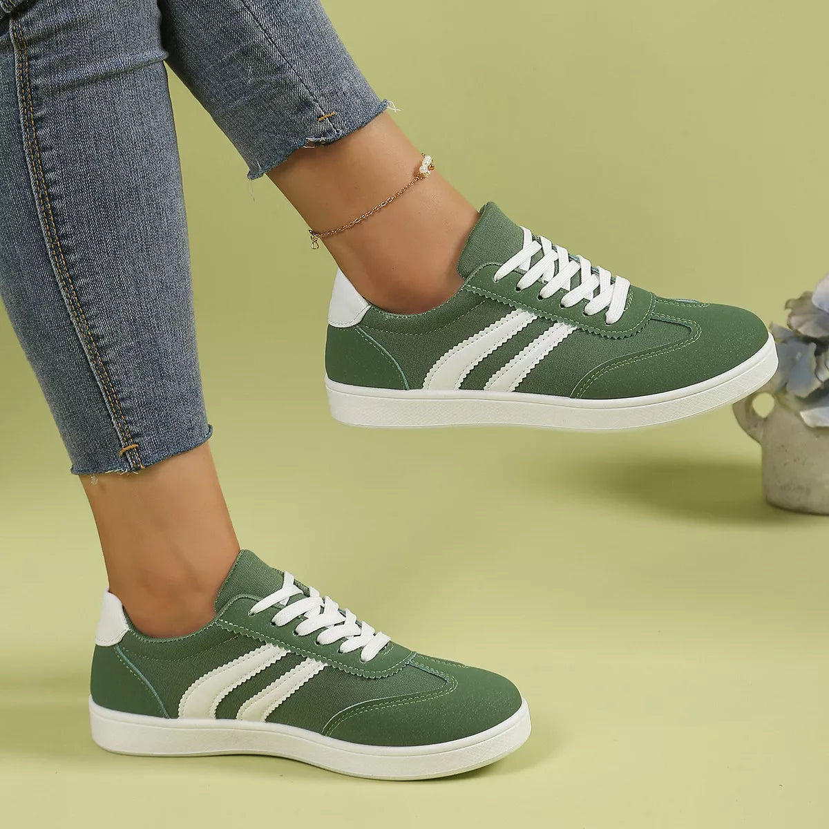 Green striped flats worn with jeans, side angle