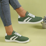 Green striped flats worn with jeans, side angle