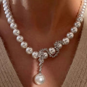 White pearl necklace with central crystal ornament and single pearl drop