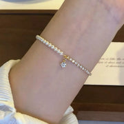 Close-up of the bracelet's tiny pearl beads and drop charm