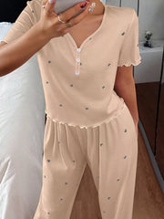 Close view of beige heart-print top with button placket and lettuce trim