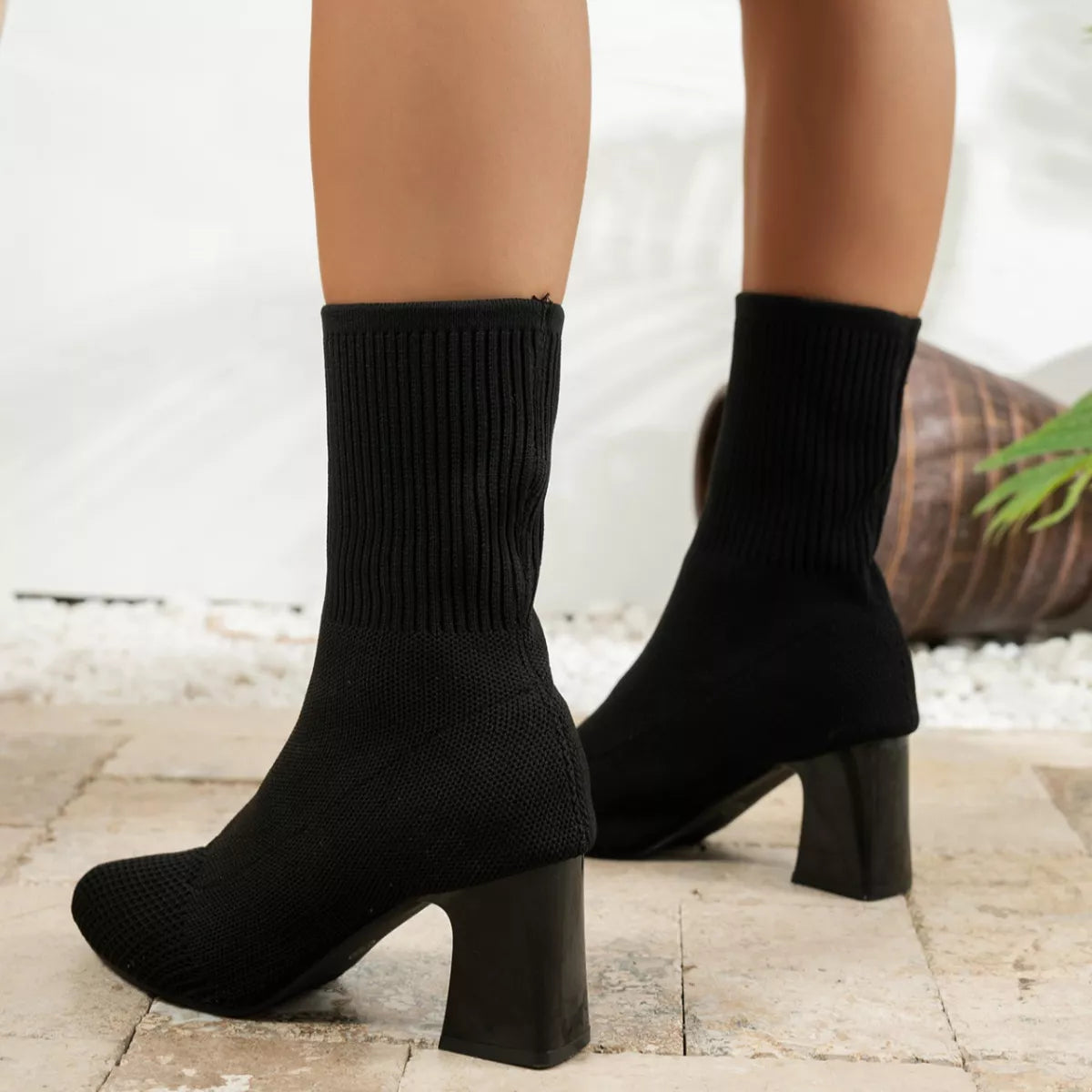 Pair of black ribbed knit sock boots shown from the front