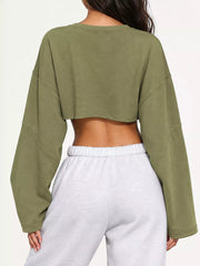Back view of an olive green cropped sweatshirt, worn with light gray sweatpants.