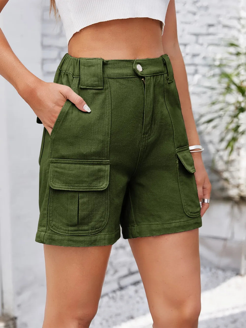 Front view of olive shorts with hands in pockets.