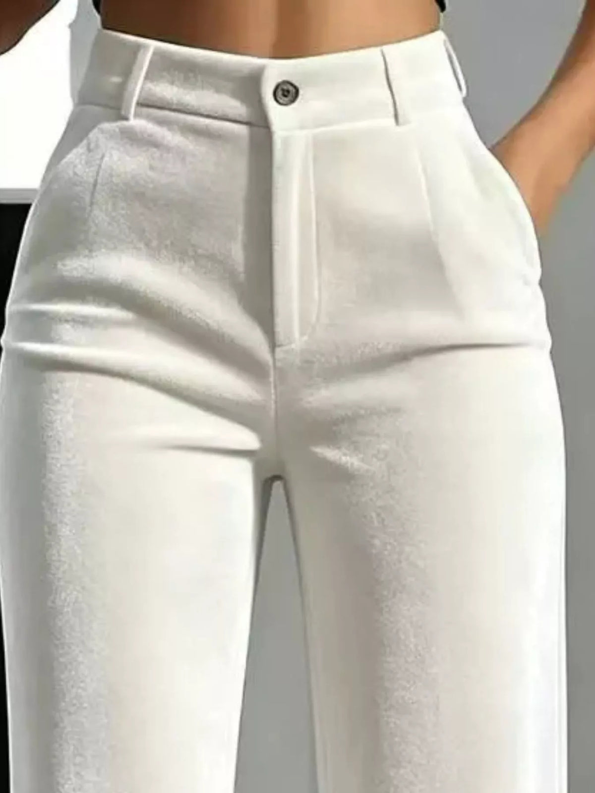 Close-up of white velvet trousers showing belt loops, button closure and front pockets