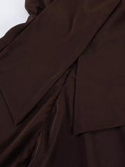 Close-up of overlapping skirt layers on the dark brown dress