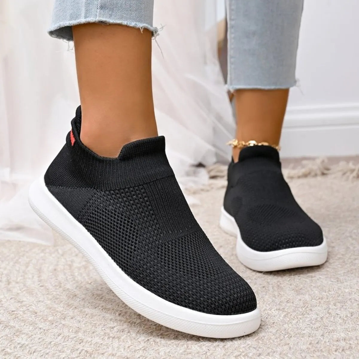 Black mesh slip-on sneakers, angled side view