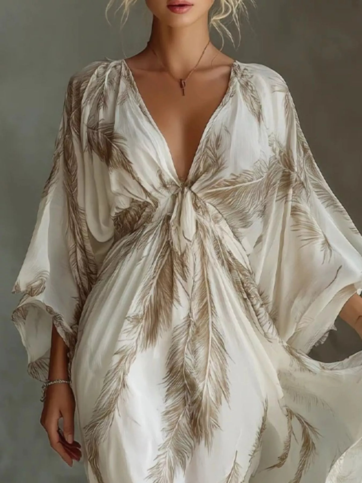 Close view of the brown feather-print maxi dress showing the tied V-neckline and loose sleeves.
